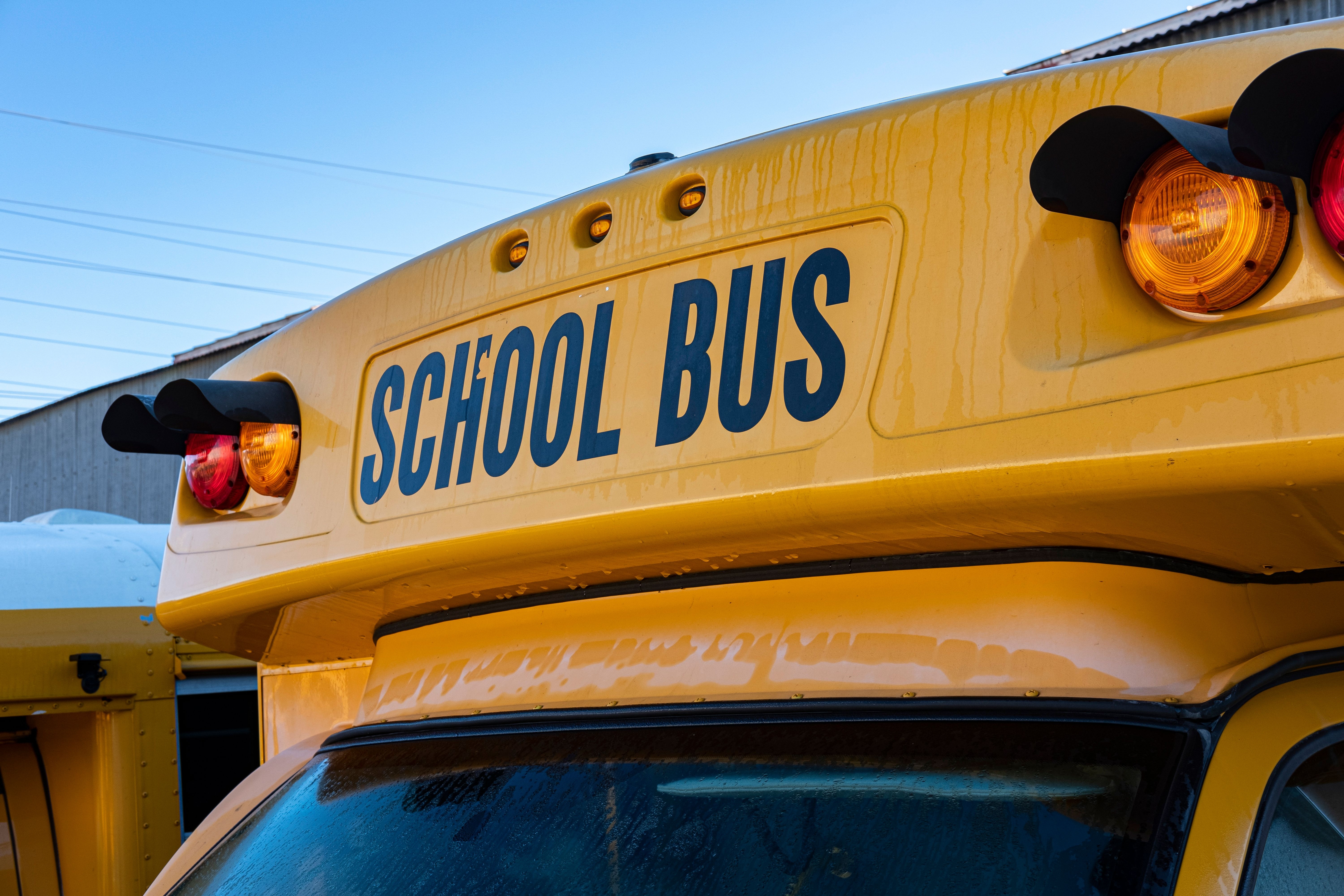 Image Front of a yellow New Jersey school bus with SCHOOL BUS sign and flashing amber and red warning signs