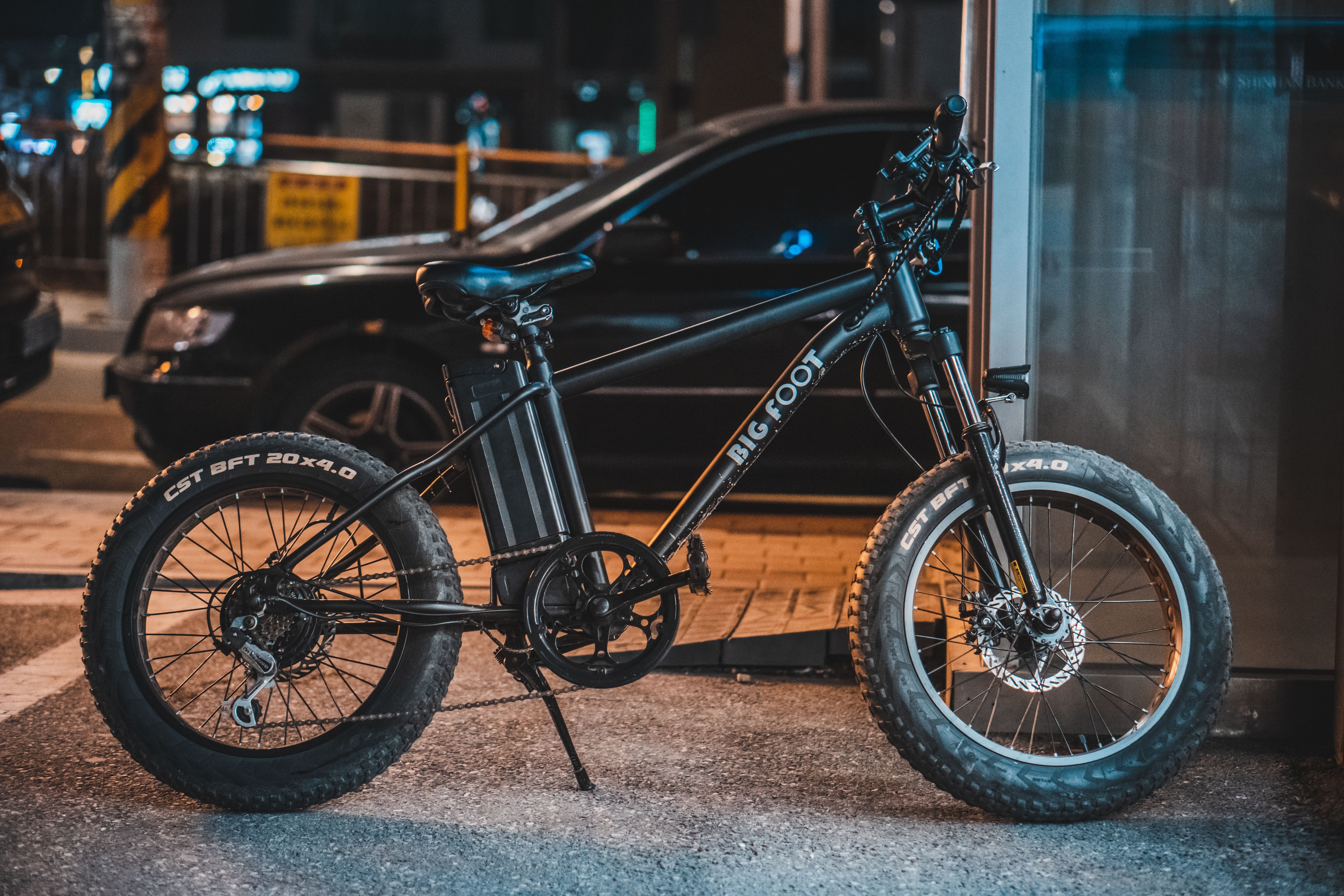 Image Black fat-tire electric bicycle with battery pack parked on a city sidewalk at night, representing e-bikes affected by New Jersey's new e-bike law