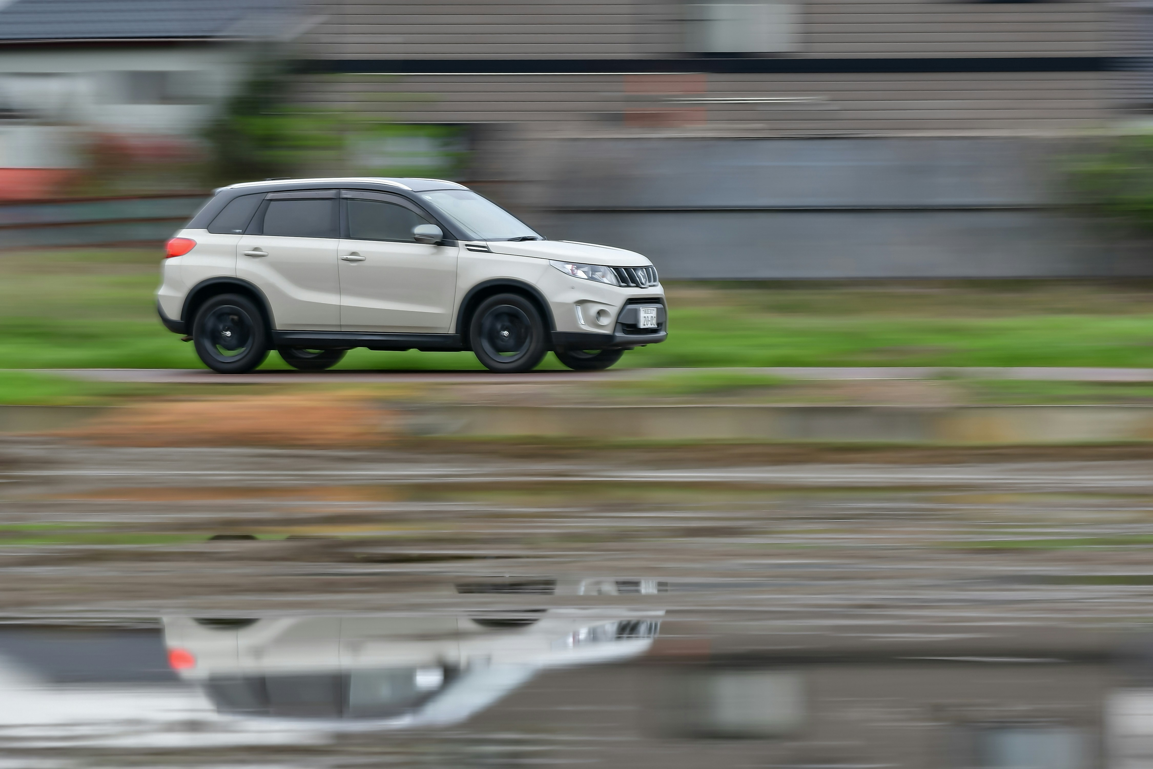 Image White SUV driving on a wet road with motion blur and water reflection, representing Easter travel accident risks in New Jersey