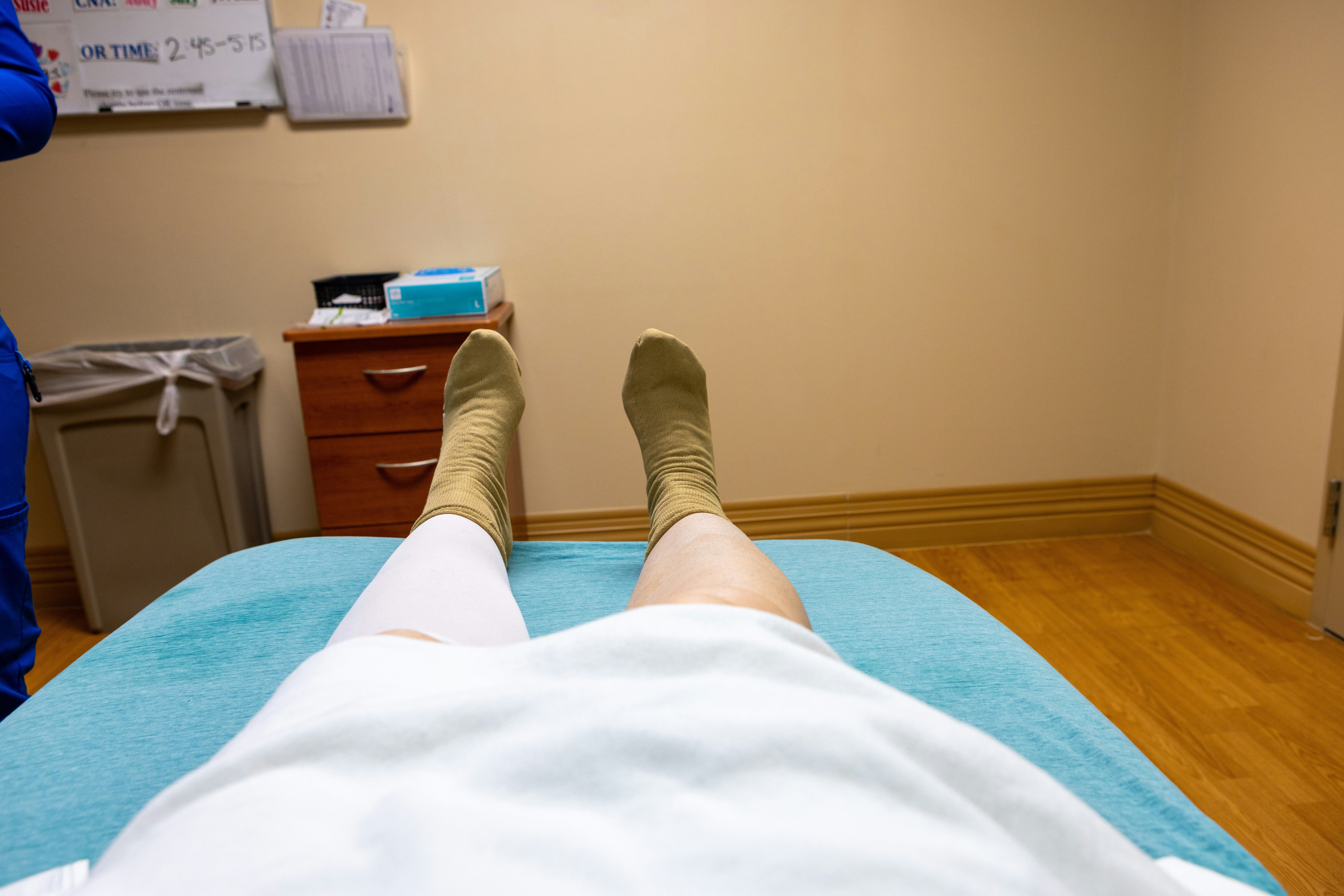 Patient lying on an exam table after a crash, showing why blood clot symptoms after a car accident need prompt medical attention.