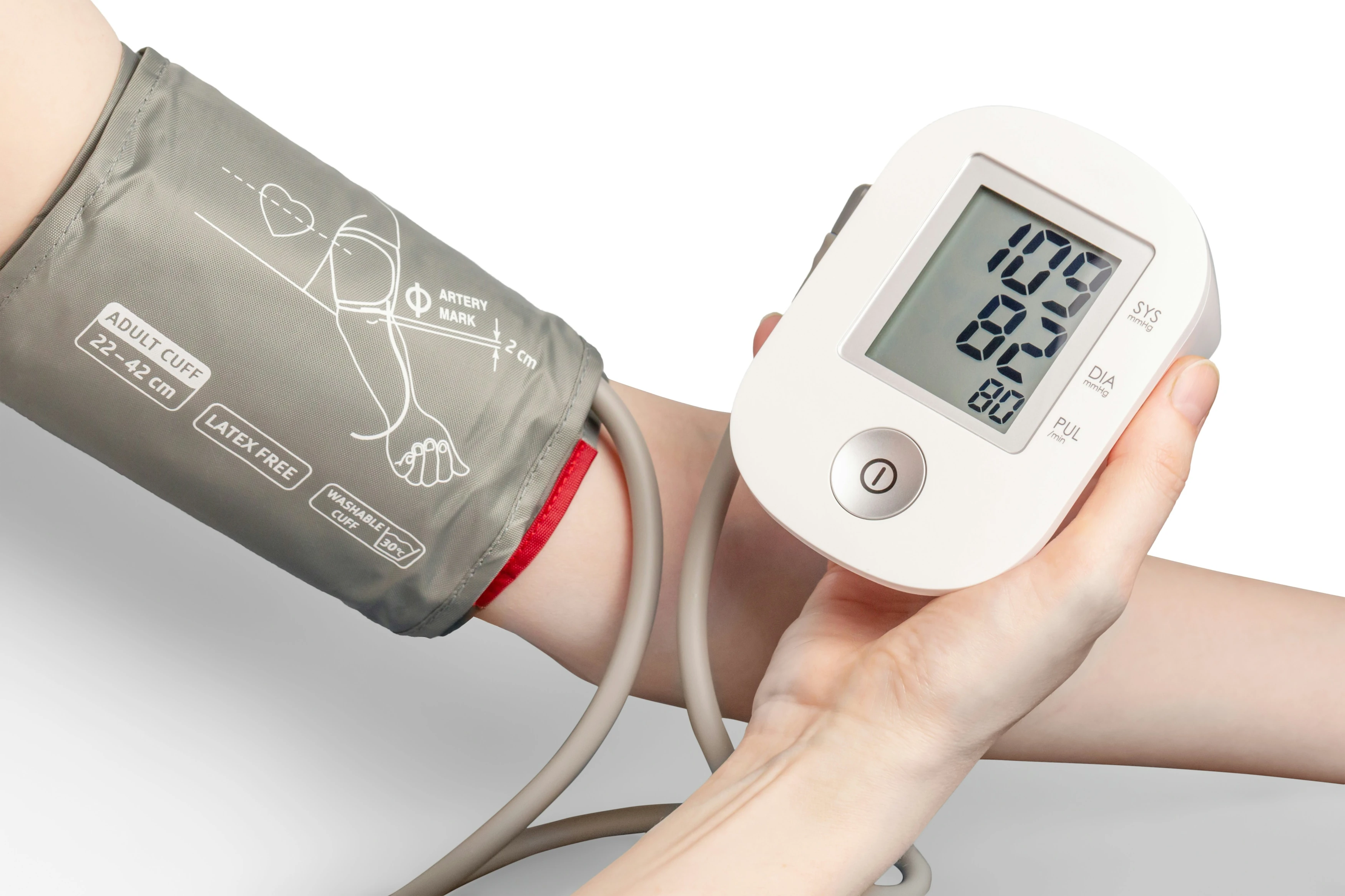 An arm in a blood pressure monitor showing systolic and diastolic pressure 