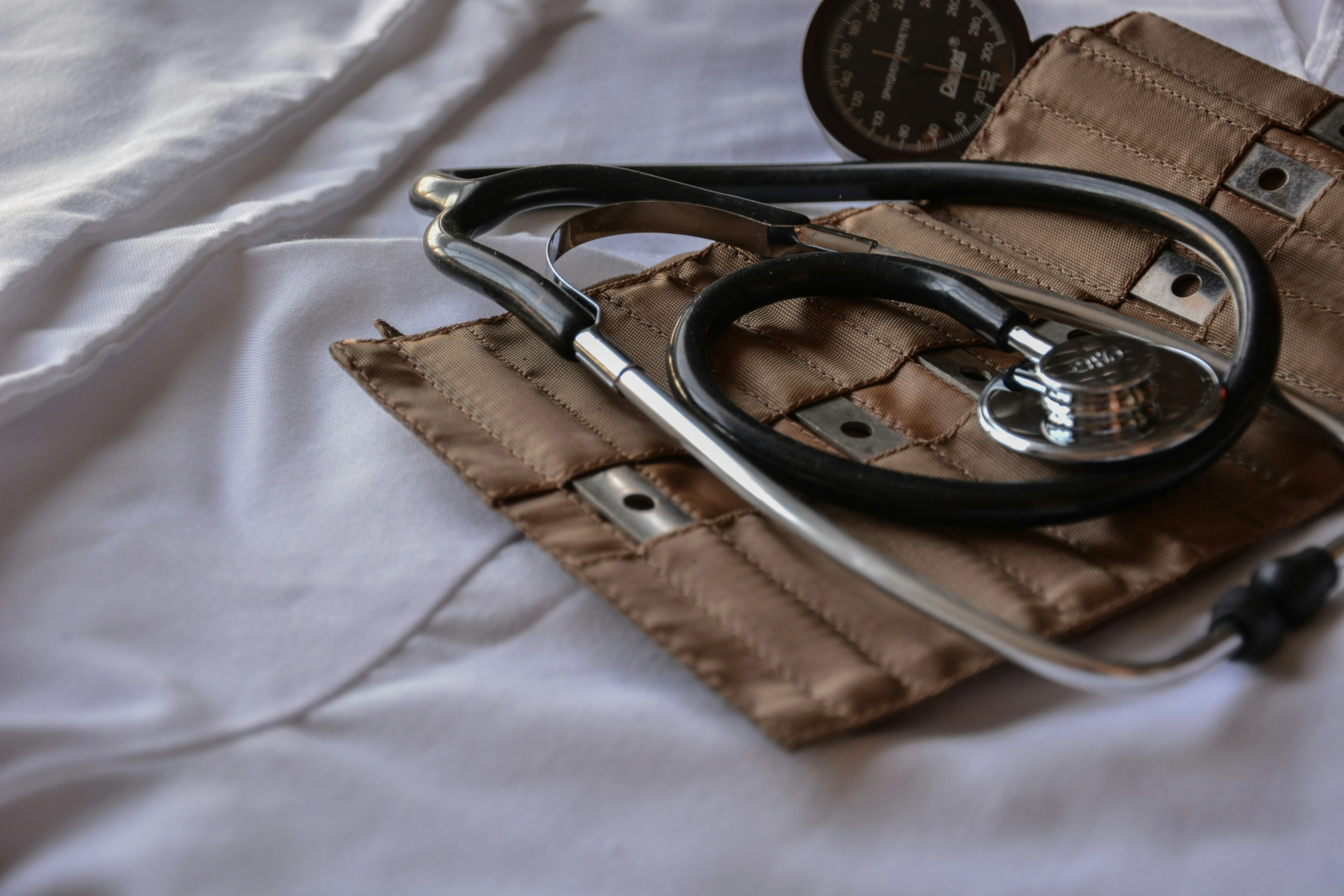 A stethoscope lying unused on a white sheet