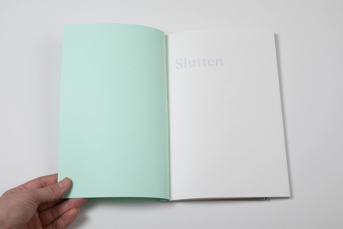 En oppslått bok som viser ordet "Slutten" mot hvit bakgrunn.