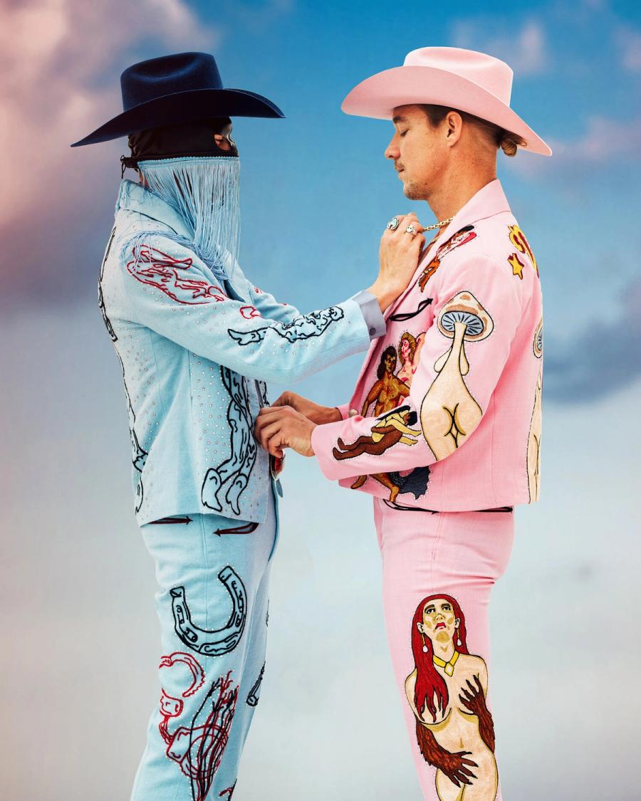 Musicians Orville Peck and Diplo wearing matching baby blue and pink suits fixing each other's clothes, photographed in New York City by fashion and celebrity photographer Taylor Miller who is located in Brooklyn, NY. 