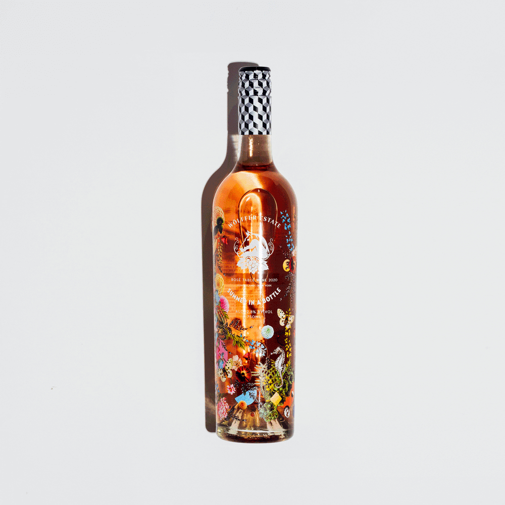 Stop motion sequence of assorted wine and champagne bottles appearing one by one on a soft gray backdrop, photographed by Taylor Miller.
