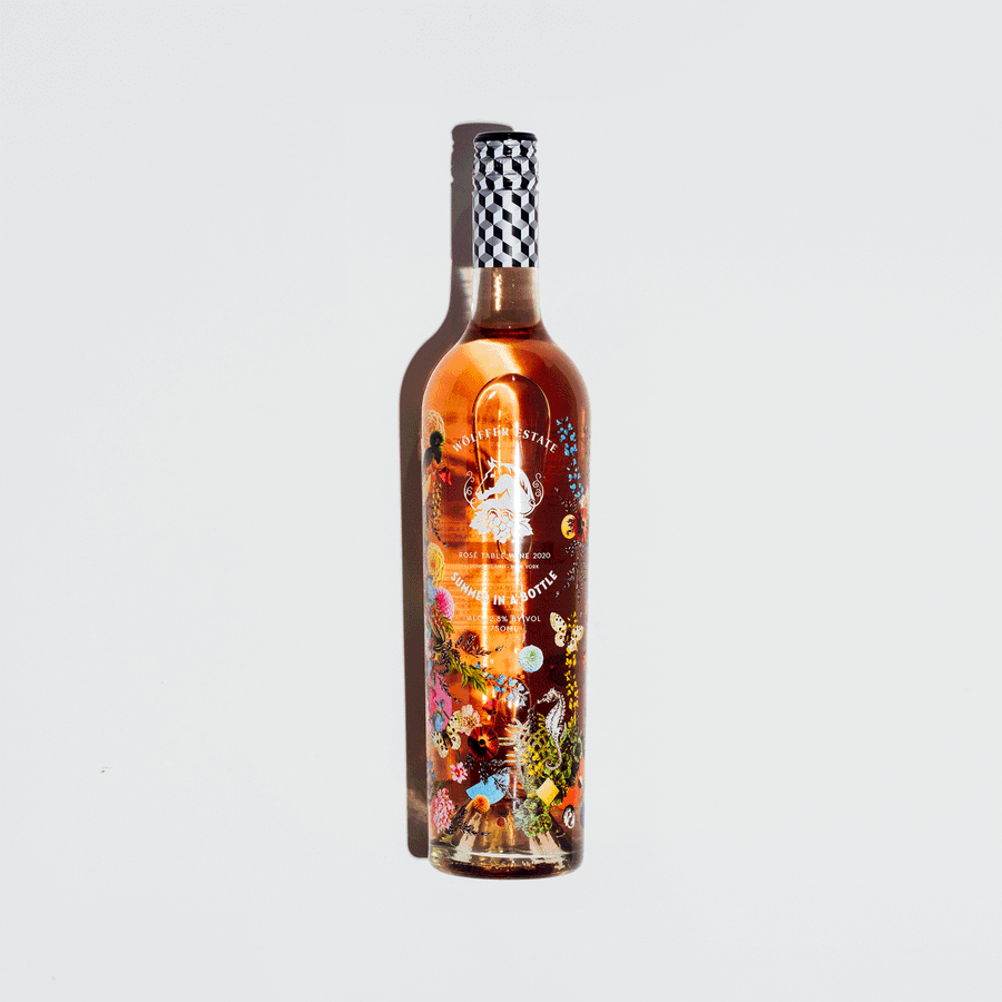 Stop motion sequence of assorted wine and champagne bottles appearing one by one on a soft gray backdrop, photographed by Taylor Miller.