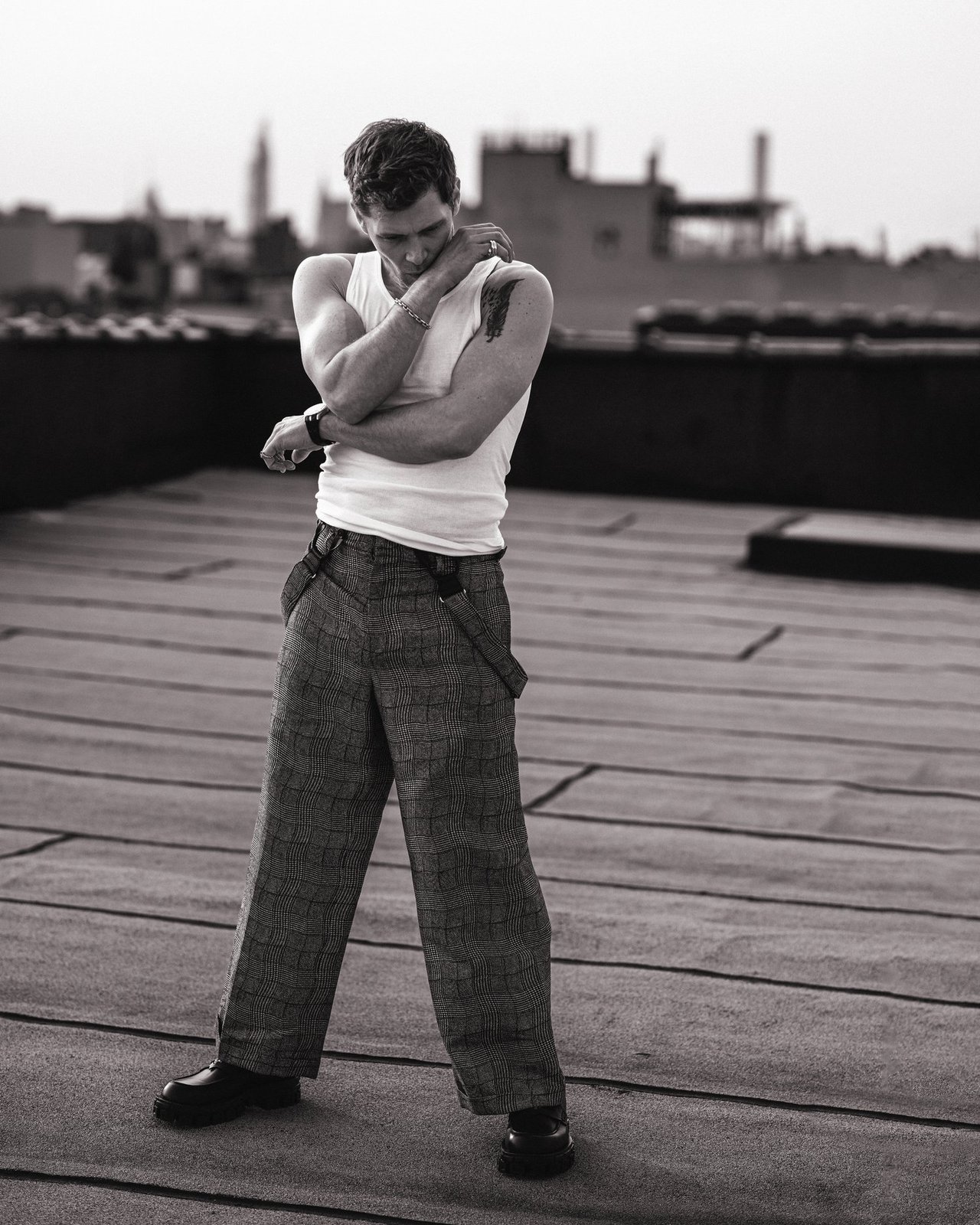 Actor Joseph Morgan, wearing a white tank top and grey patterned pants, photographed for Numéro Netherlands shot by photographer Taylor Miller.