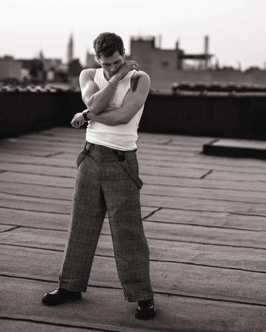 Actor Joseph Morgan, wearing a white tank top and grey patterned pants, photographed for Numéro Netherlands shot by photographer Taylor Miller.