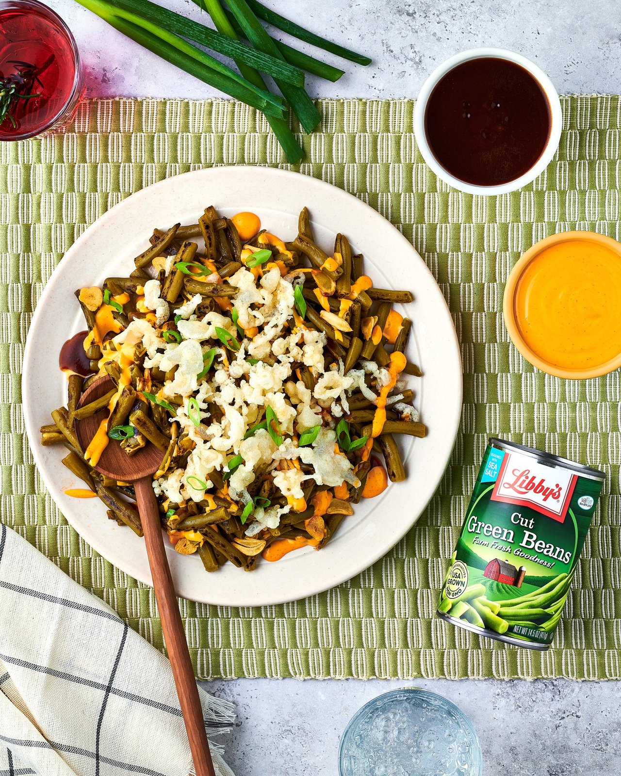Plate of green beans, carrots and rice beside a Libby's Cut Green Beans can on a green striped mat, for Libby's and BuzzFeed by Taylor Miller.