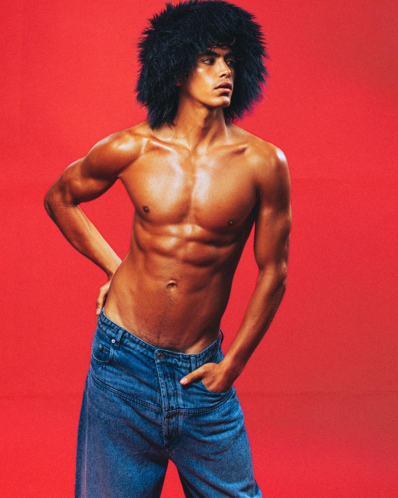 Model Sergio Perdomo, wearing a black fur hat and blue jeans, photographed for Numéro Netherlands shot by photographer Taylor Miller.