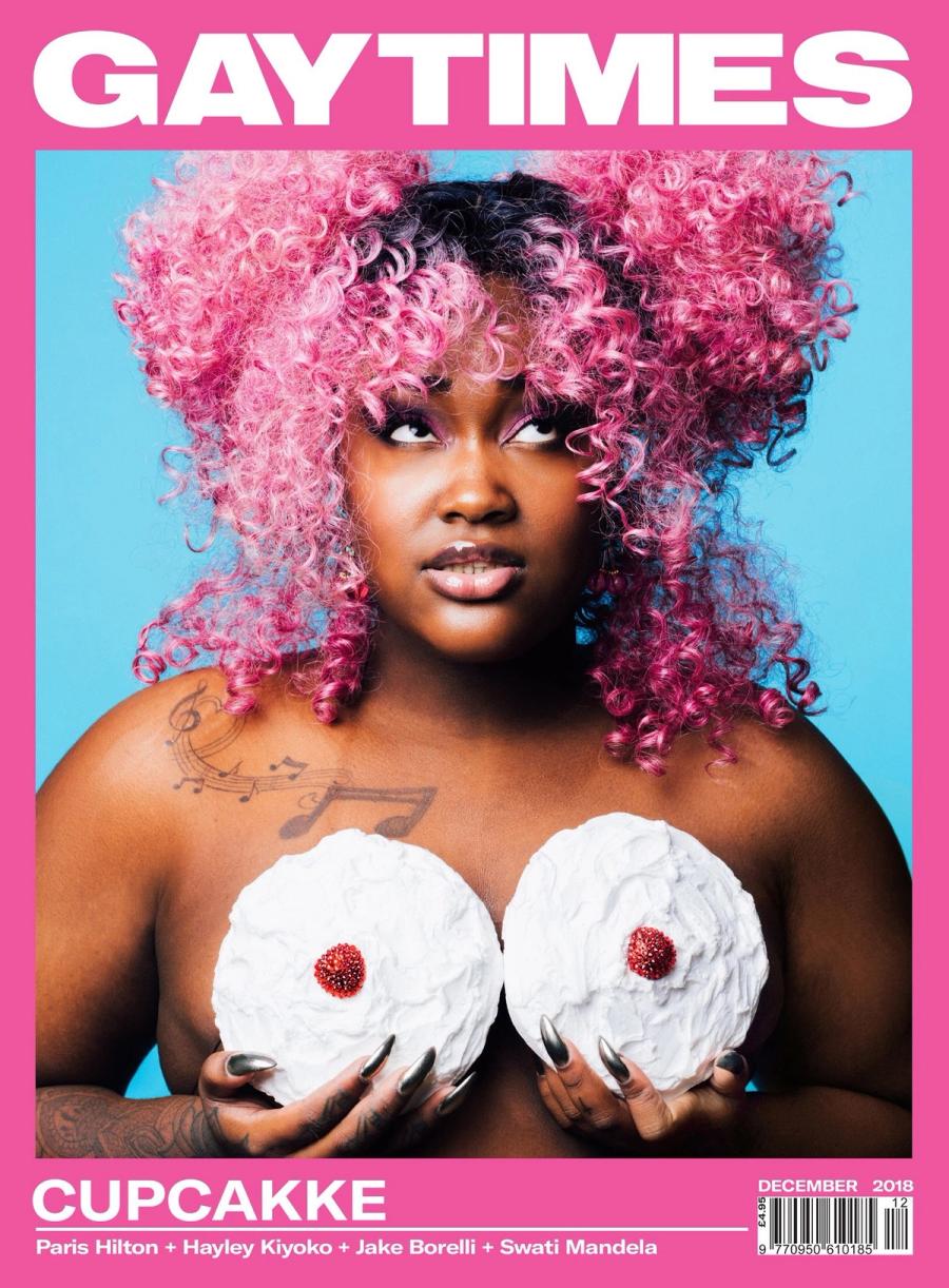 CupcakKe with pink curly hair holding two frosted cakes on the cover of Gay Times, photographed by Taylor Miller.