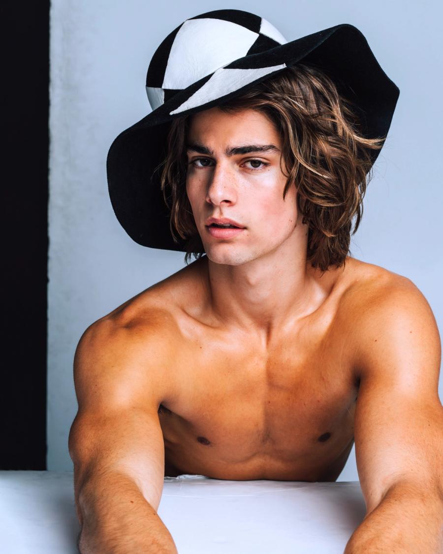 Model Corrado Martini, wearing a black and white hat, photographed for L'Officiel Hommes Poland shot by photographer Taylor Miller.