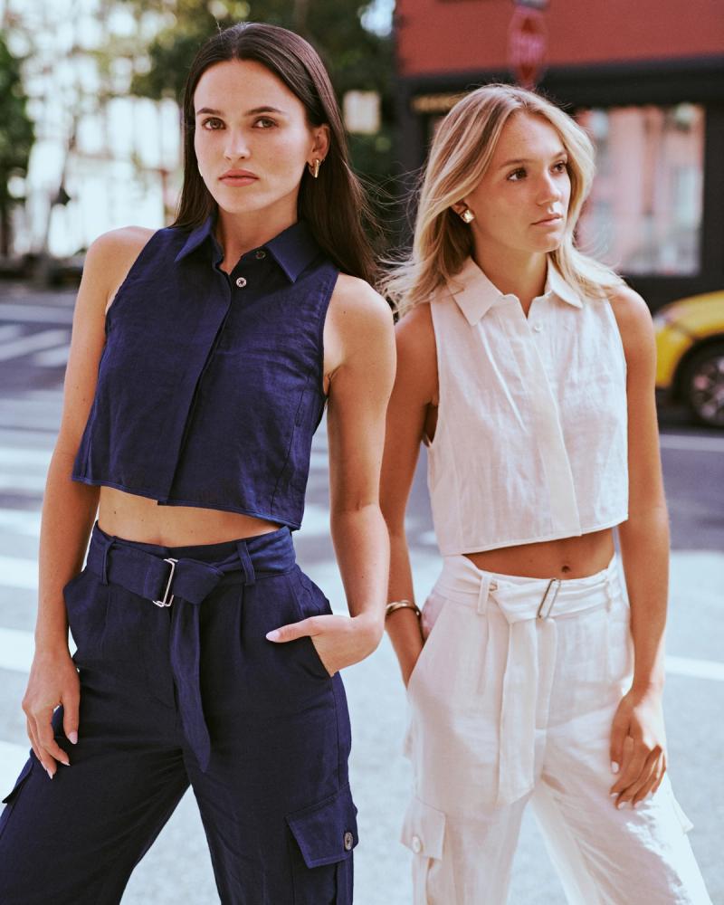 Mary Holland Nader and Julia Lisboa in navy and cream linen crop-top and trouser sets crossing a city street for the ESYA editorial campaign, photographed by Taylor Miller.
