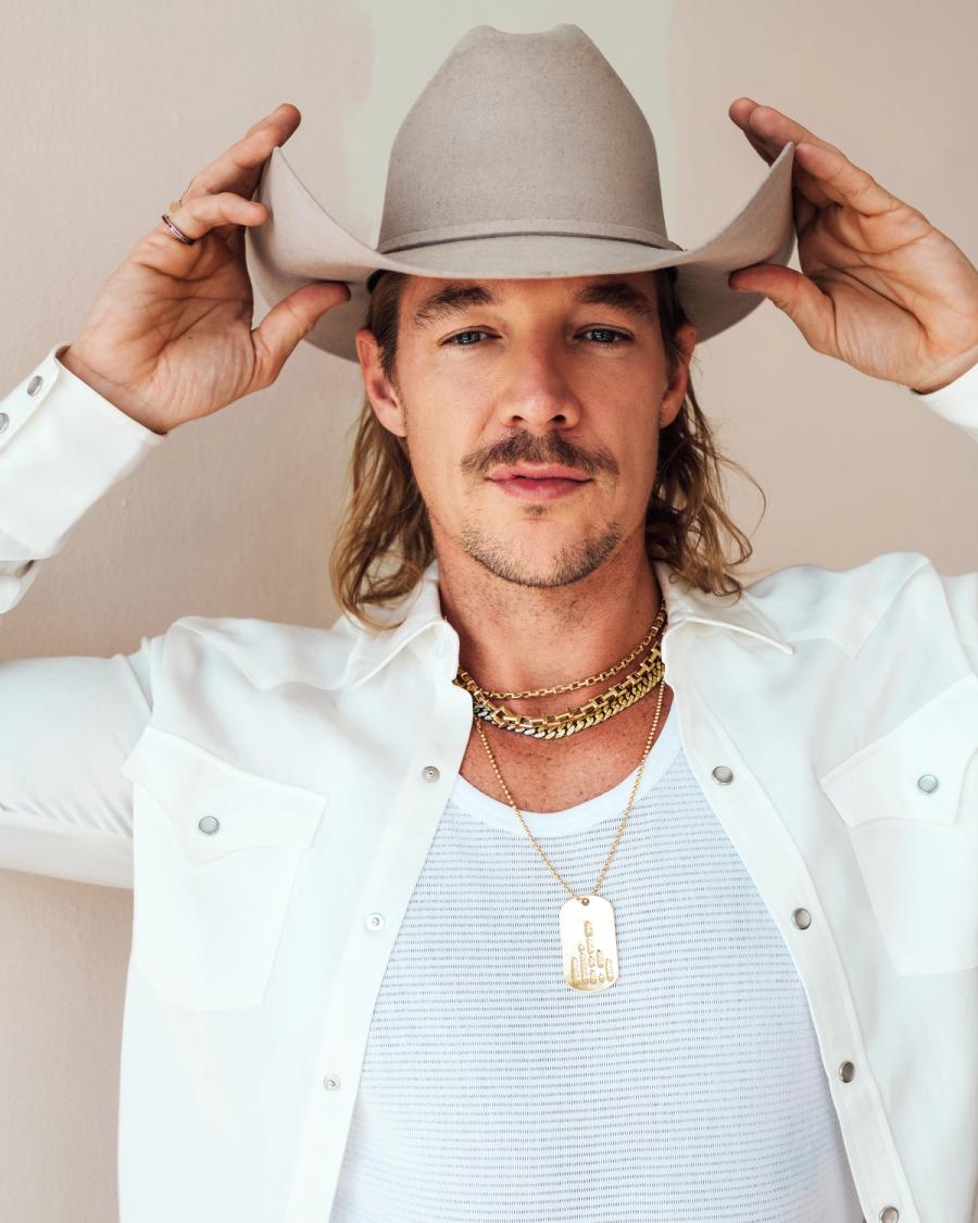 Diplo in a white western shirt and cowboy hat layered with gold chains, photographed by Taylor Miller.