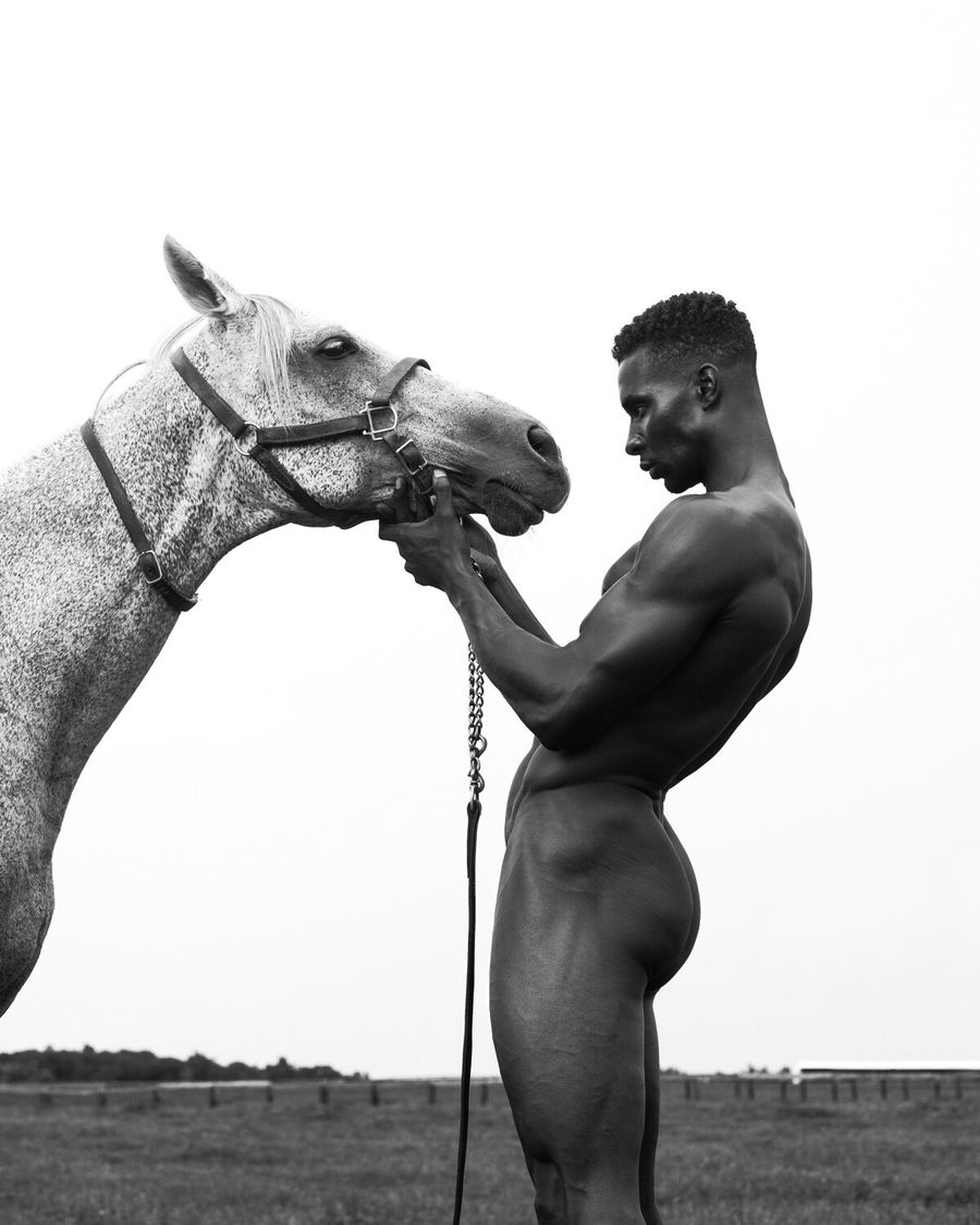 Model Joshua Cummings, posing with a horse, photographed for L'Officiel Hommes shot by photographer Taylor Miller.