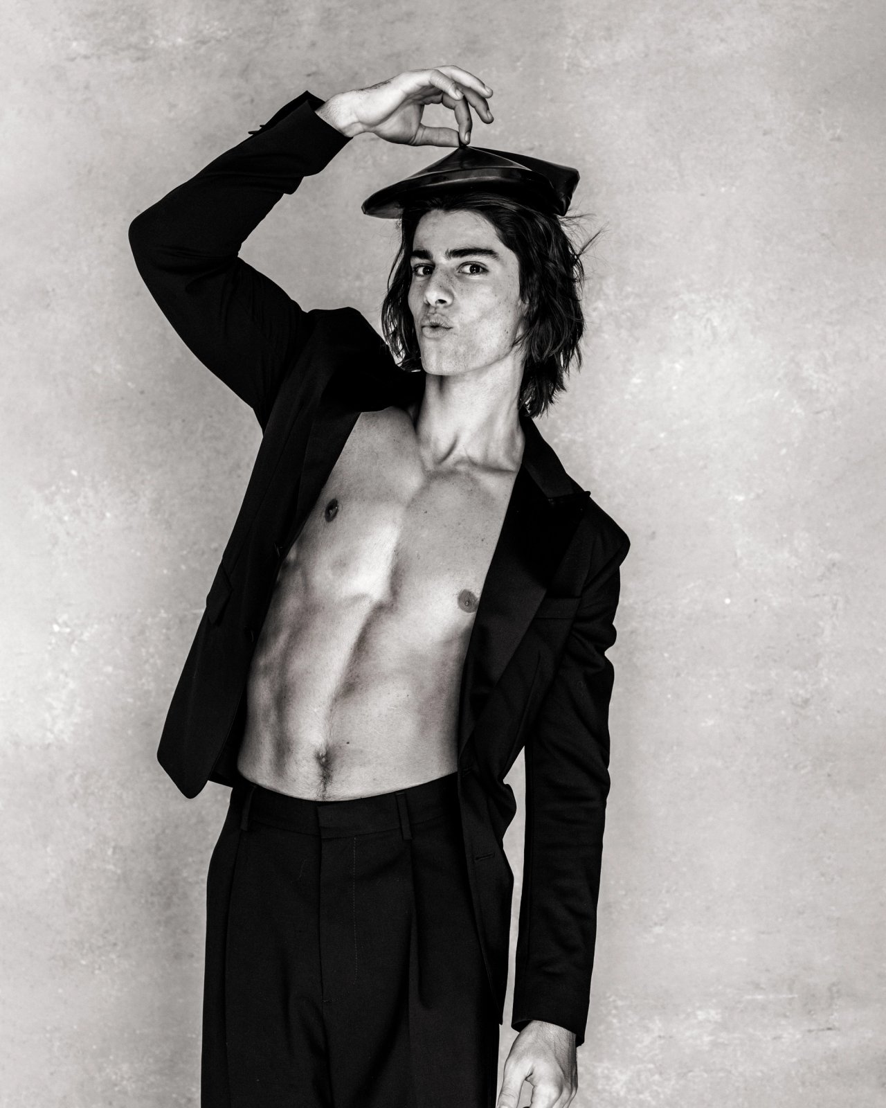 Model Corrado Martini, wearing a black shirt and pants with a baret, photographed for L'Officiel Hommes Poland shot by photographer Taylor Miller.