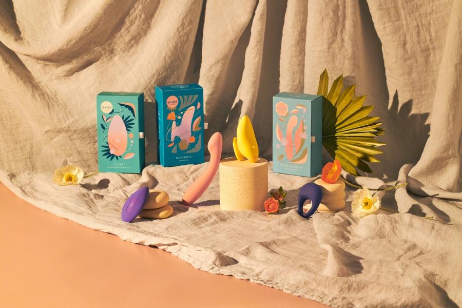 Goodful x Pipedream vibrators displayed with their teal Float, Daffodil and Wild Flower boxes and flowers on draped linen, photographed for BuzzFeed by Taylor Miller.