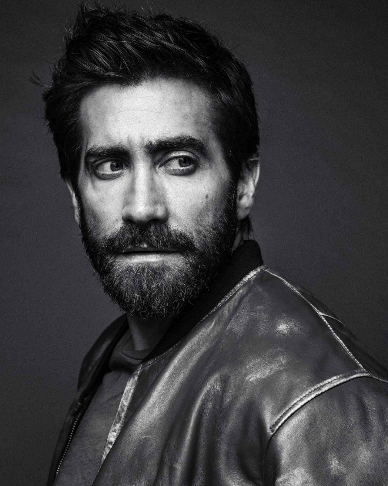 Actor Jake Gyllenhaal wearing a leather jacket and posing looking over his shoulder photographed in New York City by fashion and celebrity photographer Taylor Miller who is located in Brooklyn, NY. 