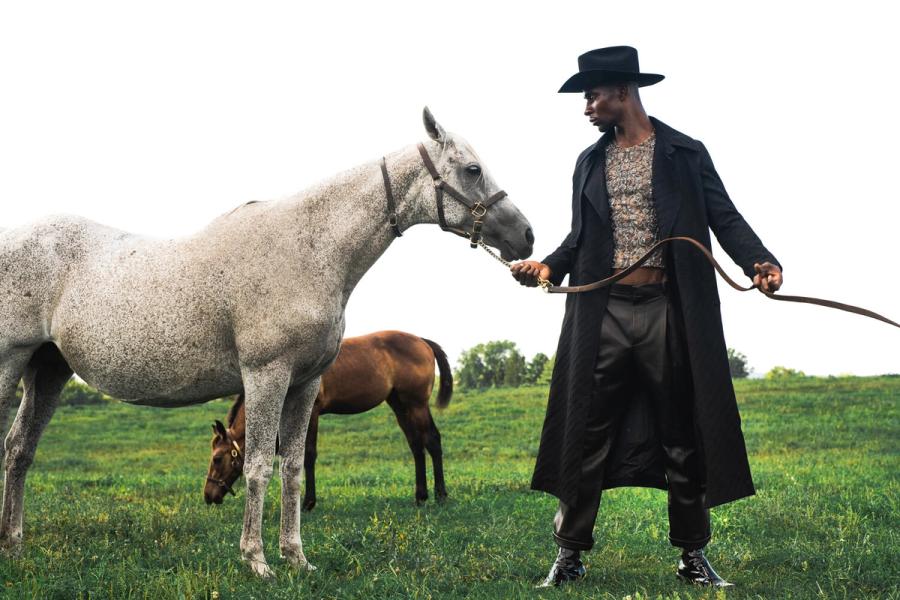 Model Joshua Cummings, posing with a horse, photographed for L'Officiel Hommes shot by photographer Taylor Miller.
