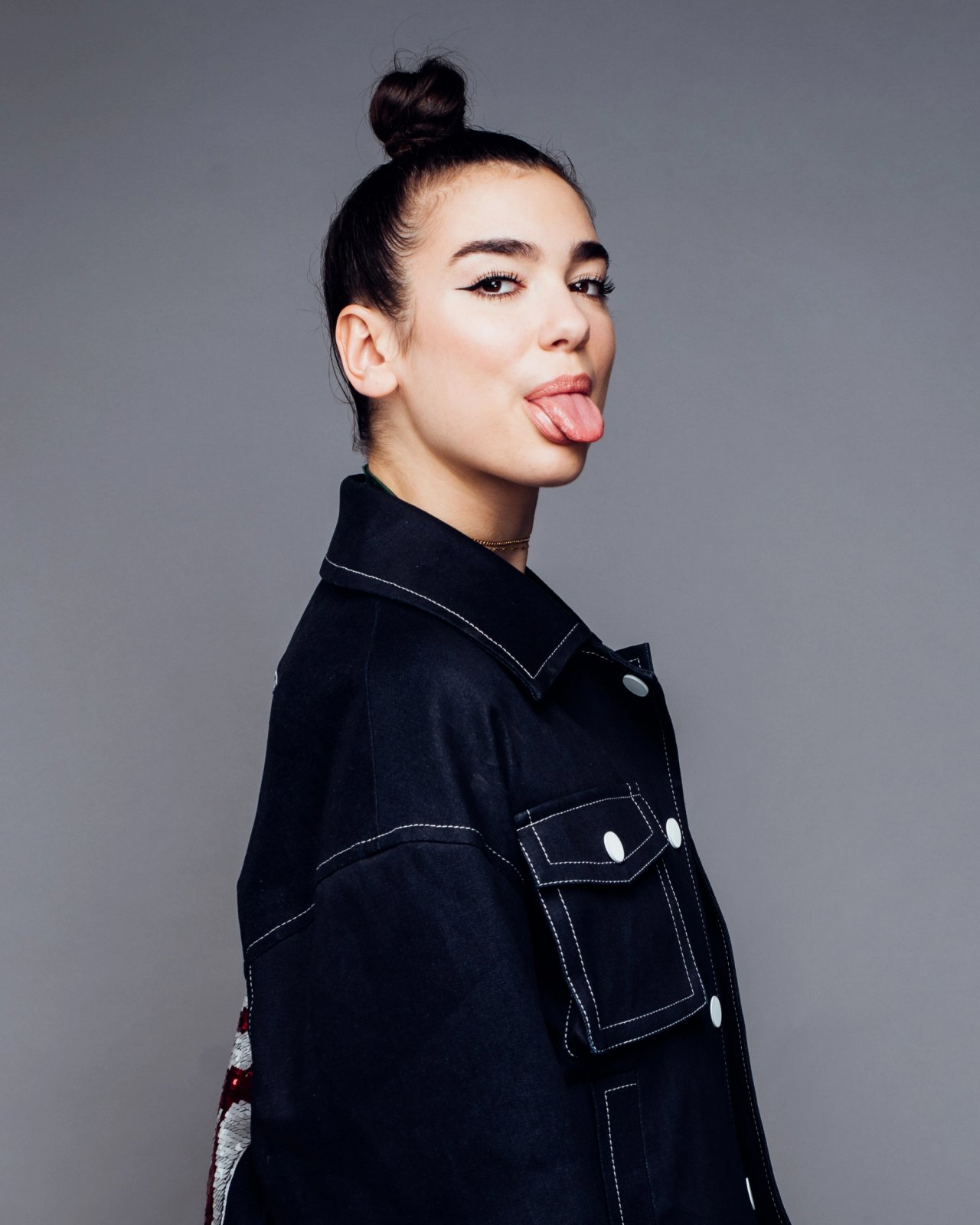 Superstar singer Dua Lipa, sticking her tongue out wearing a denim jacket, photographed in New York City by fashion and celebrity photographer Taylor Miller who is located in Brooklyn, NY. 