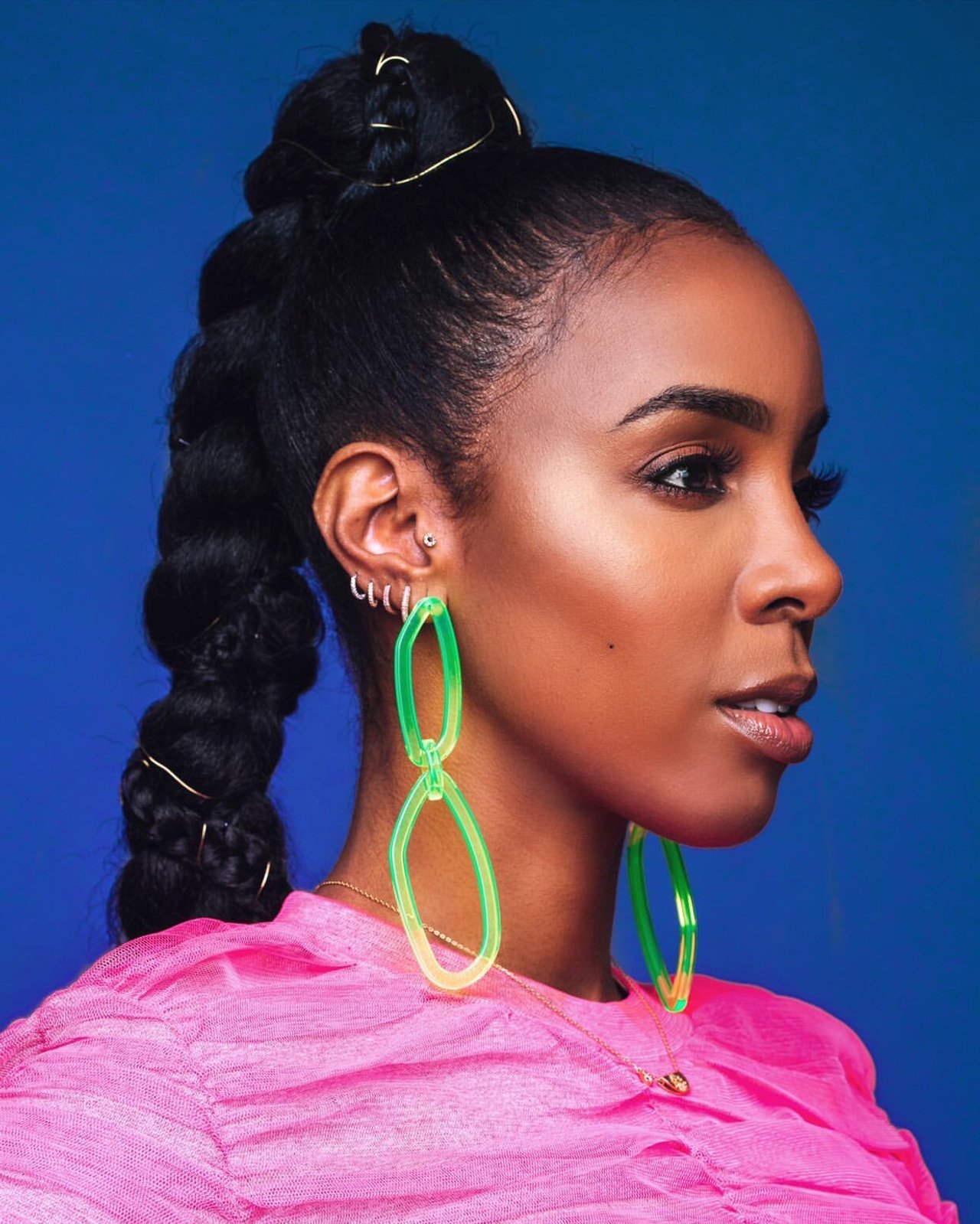 Singer Kelly Rowland, wearing a pink dress and neon green earrings, photographed in New York City by fashion and celebrity photographer Taylor Miller who is located in Brooklyn, NY. 