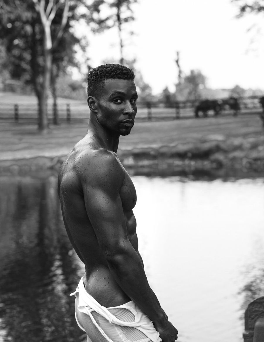 Model Joshua Cummings, wearing white pants, photographed for L'Officiel Hommes shot by photographer Taylor Miller.
