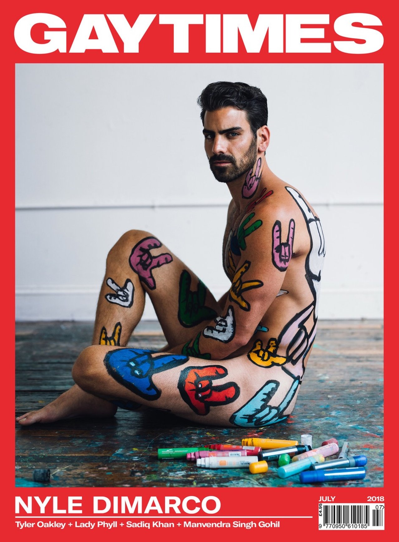 Nyle DiMarco seated nude with colorful sign-language hand art painted across his body on the cover of Gay Times, photographed by Taylor Miller.