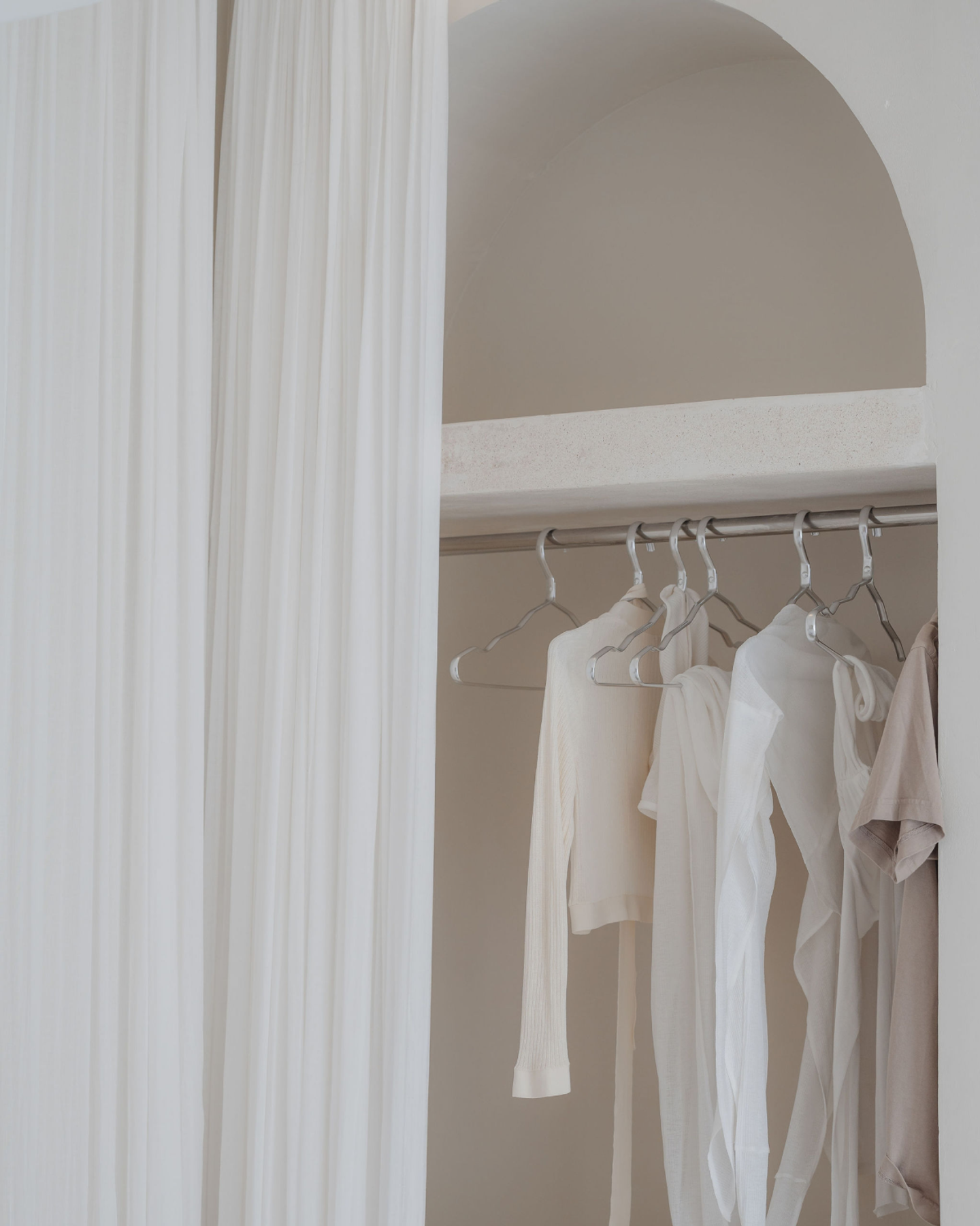 House of Creations Bali – Minimalist Wardrobe and Architectural Alcove Neutral-toned wardrobe with light drapery and curated closet in arched alcove, modern villa interior branding and design at House of Creations Bali