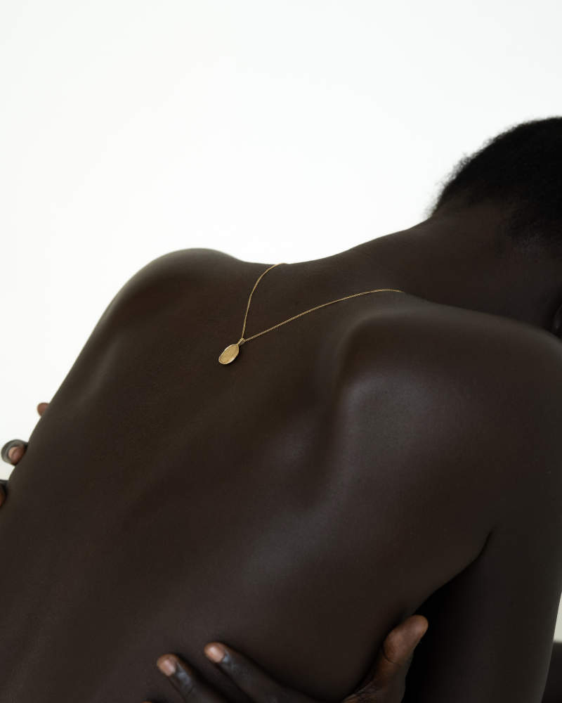 OMOI Jewelry Forever Pendant – Minimal Back Portrait by Eeze Studio Minimal portrait of model’s back with OMOI Jewelry gold Forever Pendant draped along spine, created for branding and Shopify website experience by Eeze Studio