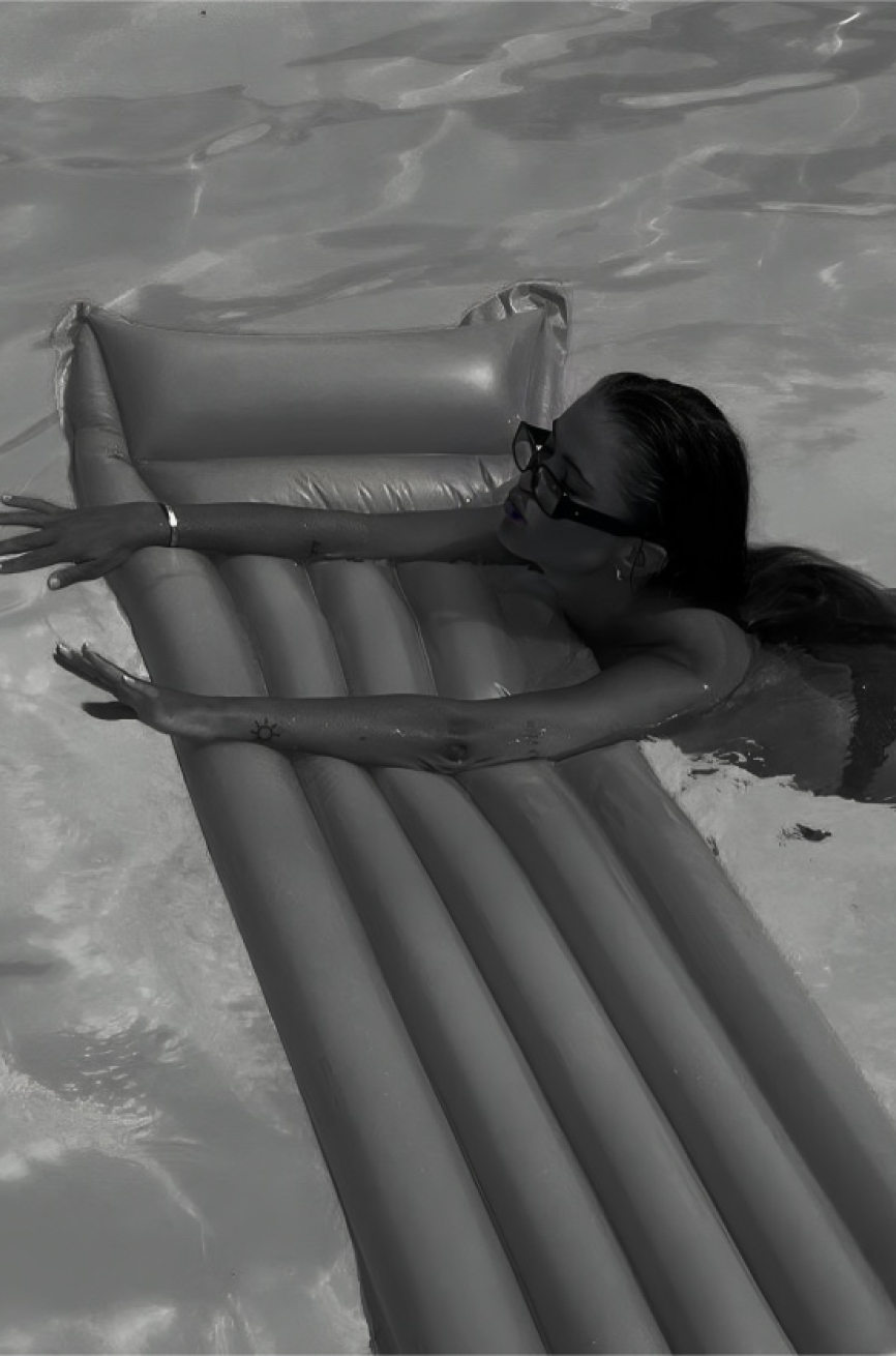 OREUM Art Direction—Lifestyle Pool Editorial Branding by Eeze Studio Editorial branding visual for OREUM project featuring a person relaxing on a minimalist pool float in bright water; art direction and brand identity crafted by Eeze Studio for high-end lifestyle brands.