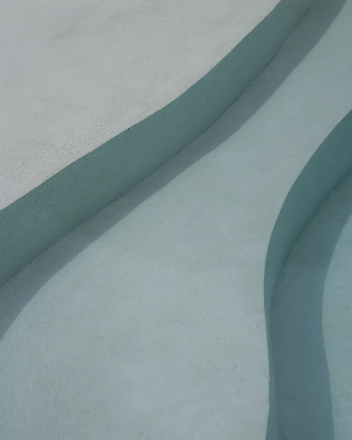 House of Creations Bali – Minimalist Pool Edge and Organic Architecture Closeup detail of minimalist organic pool edge and steps, luxury villa architectural design and branding at House of Creations Bali