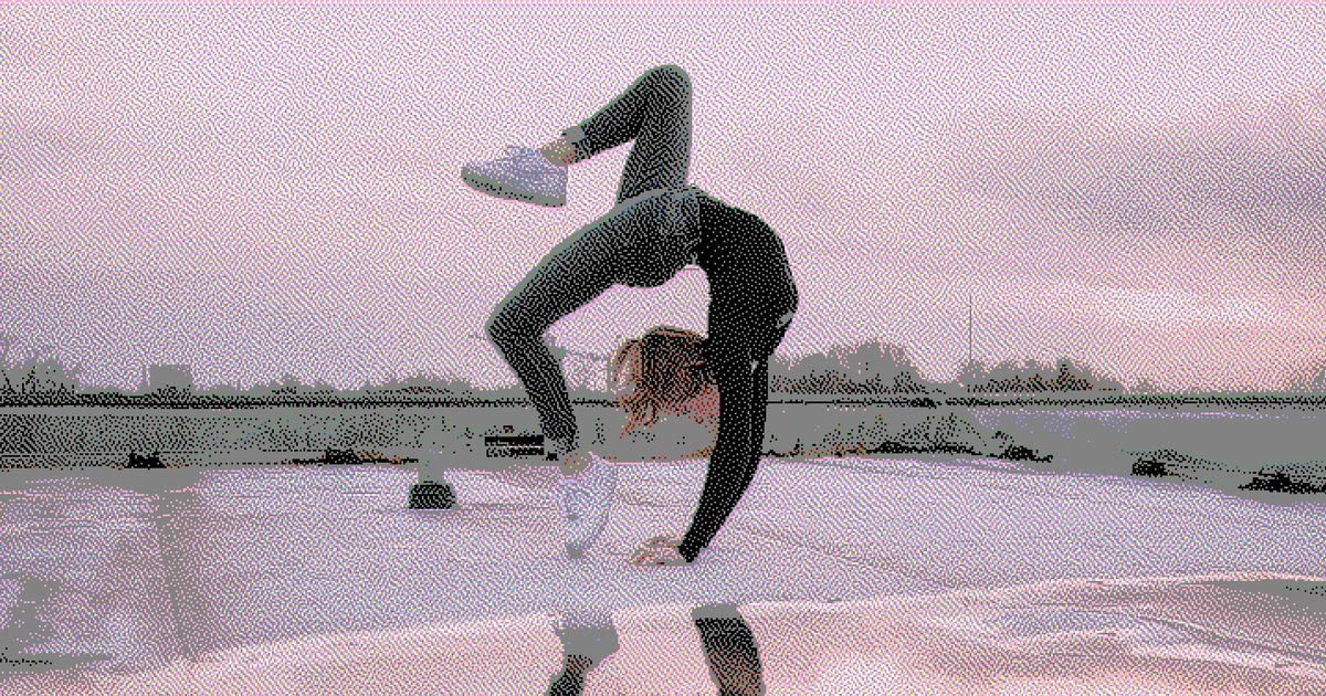 Female dancer doing an extreme back bend on a rooftop