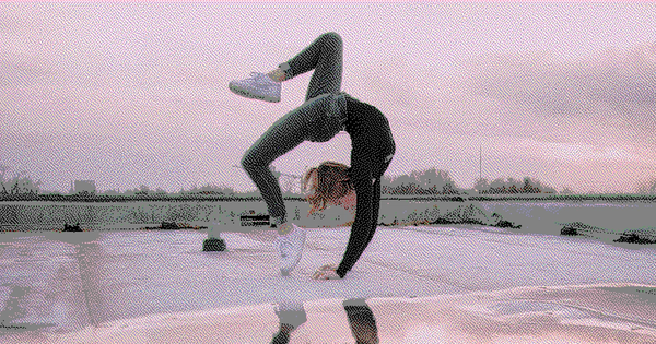 Female dancer doing an extreme back bend on a rooftop