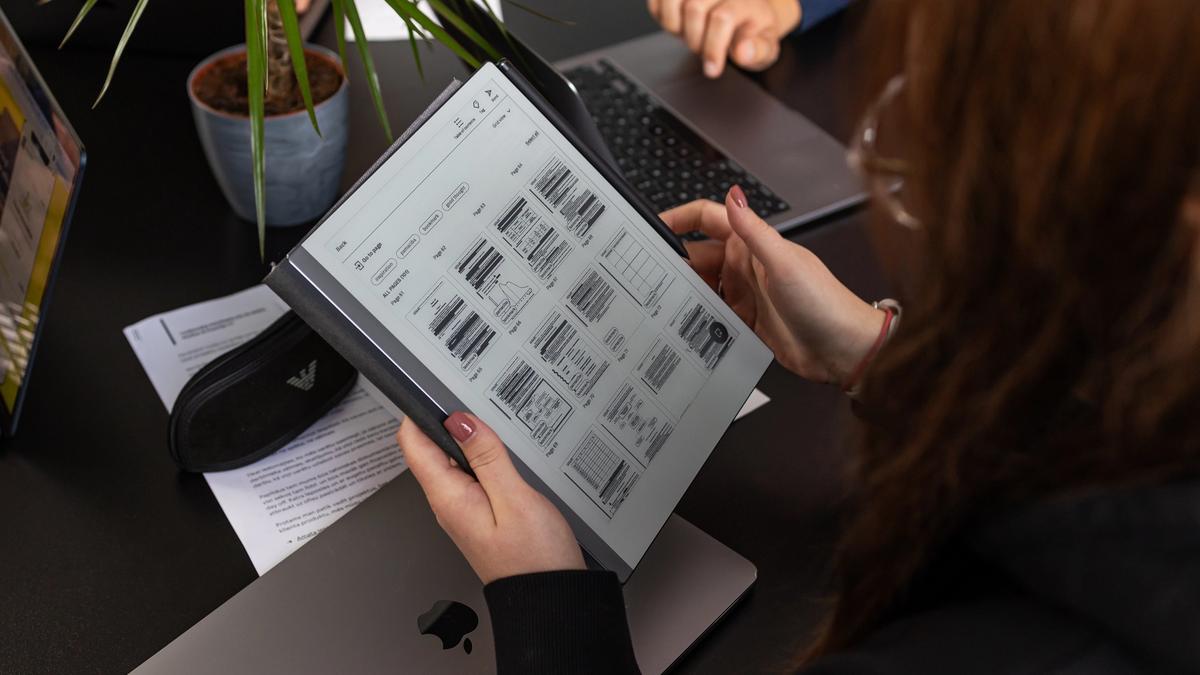 UX dizainere pārskata maketus un prototipus uz planšetdatora