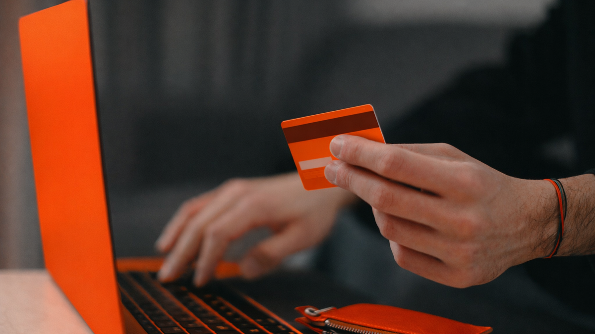 Person making an online payment with a credit card on a laptop