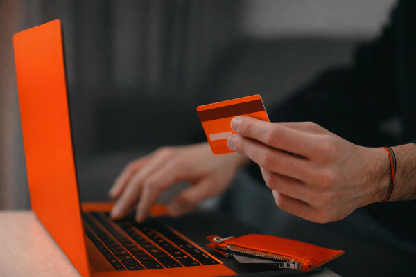 Person making an online payment with a credit card on a laptop