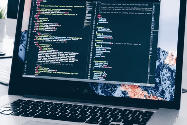 Mājas lapu izstrāde - dators ar mājaslapas pirmkodu datora ekrānā