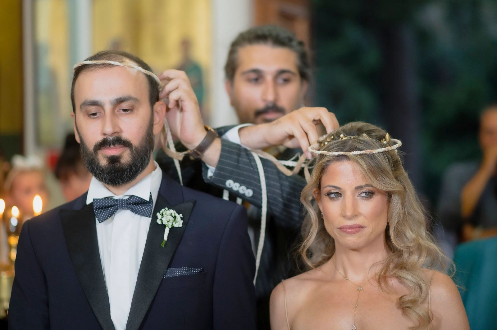Ο κουμπάρος τοποθετεί τα στέφανα στα κεφάλια του γαμπρού και της νύφης στην εκκλησία.