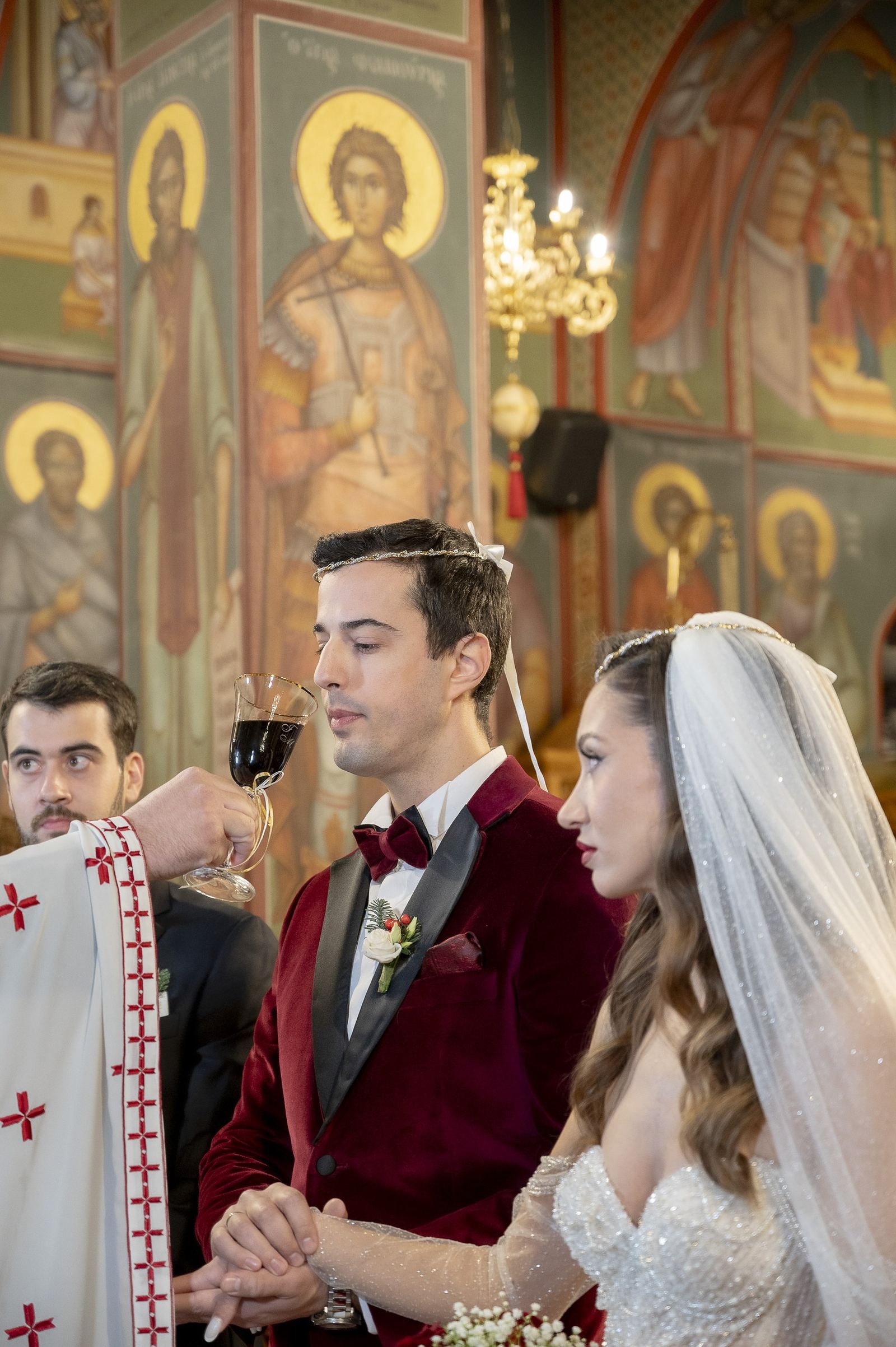 The priest offers the common cup to the crowned couple beneath church icons