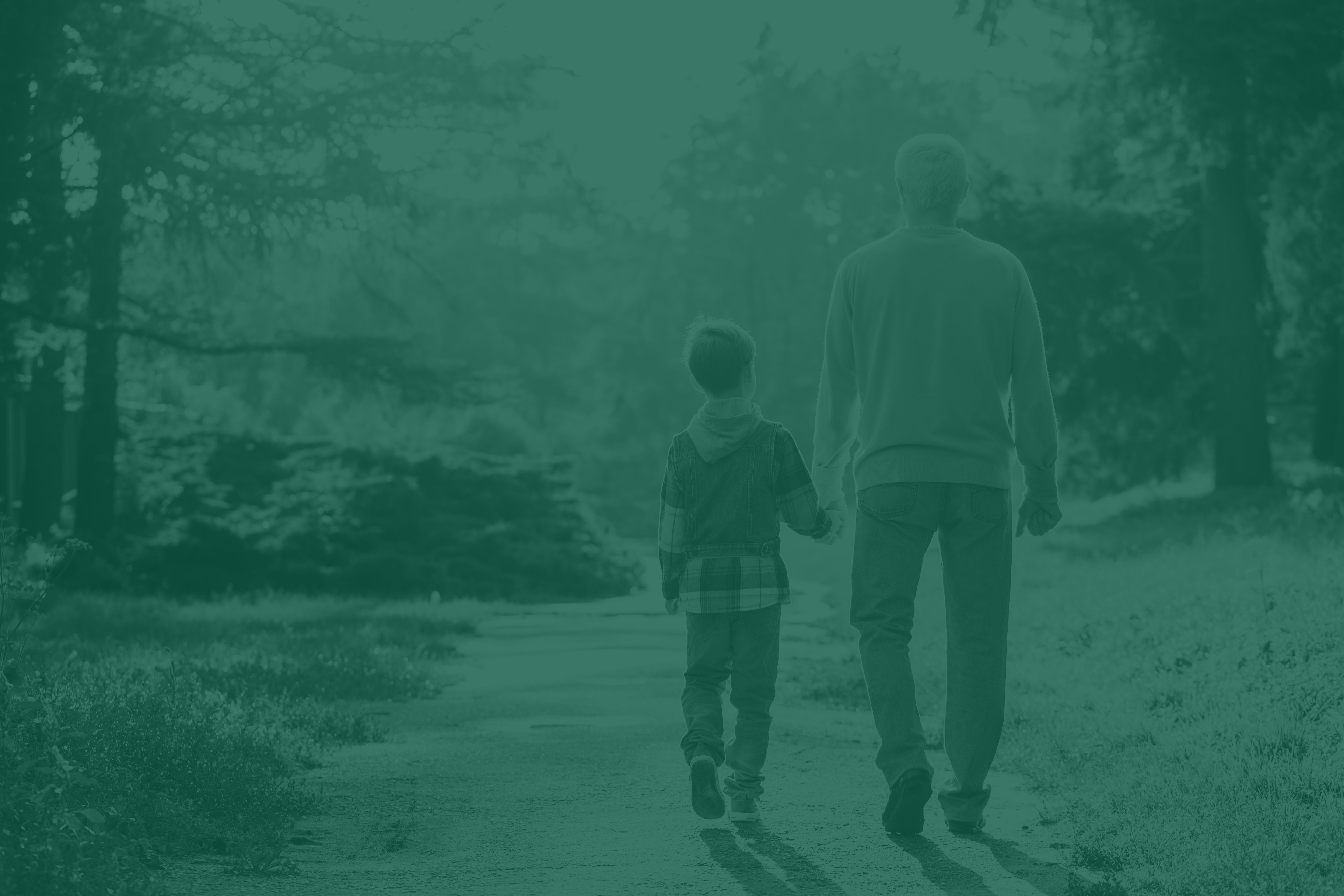 An adult and child walking down a forest path together.