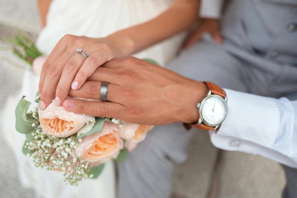 a wedding photo of two hands with their new wedding rings