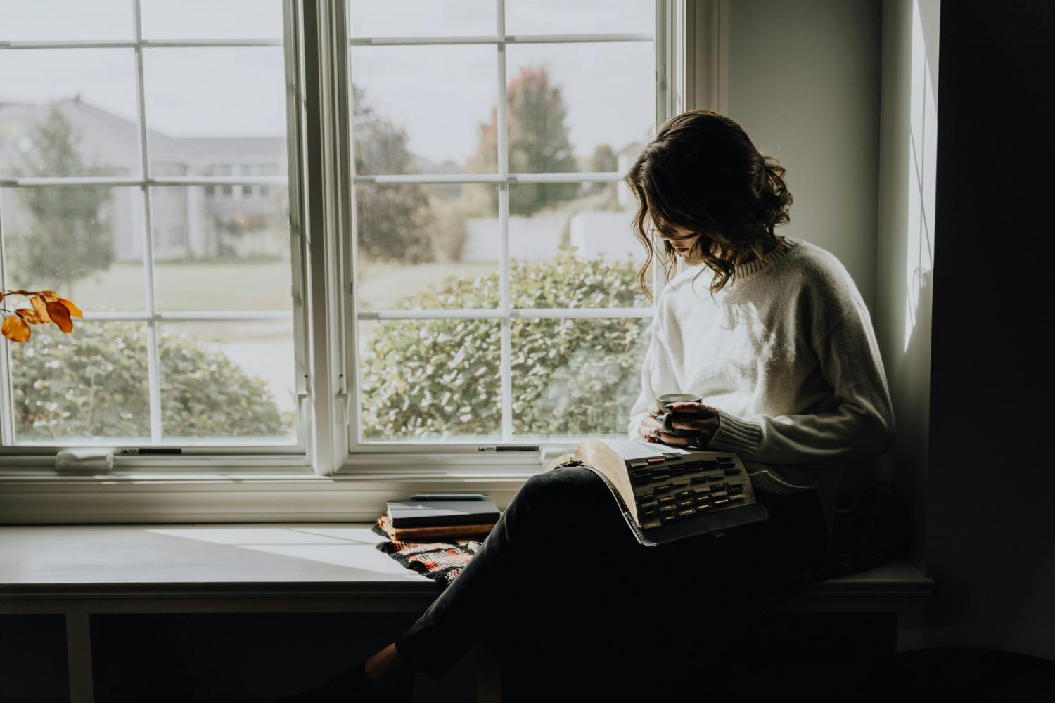 Reading a Bible by a window