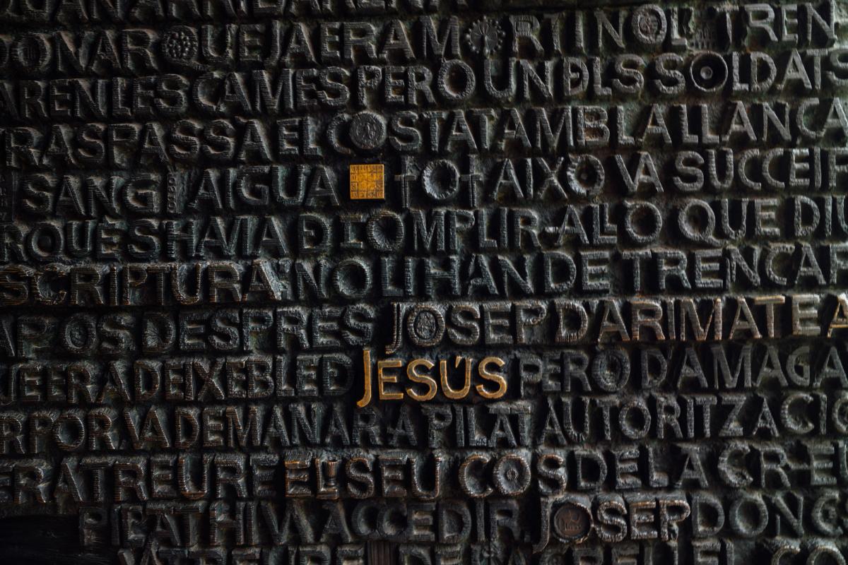 A wall of metal text with the name of Jesus in bright colouring 