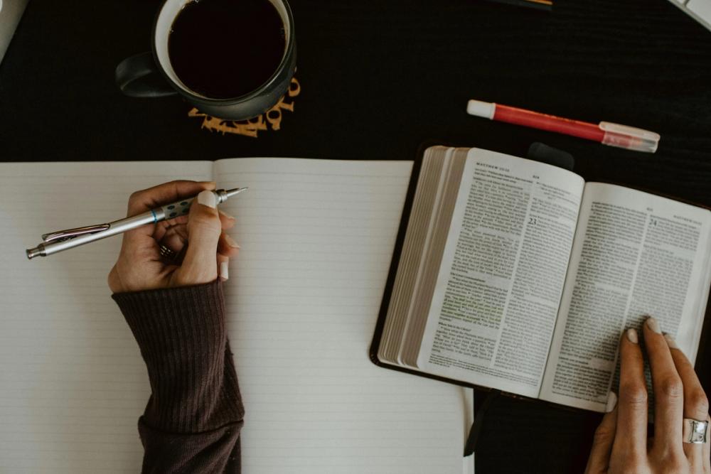 Studying the Bible with a notepad and pen