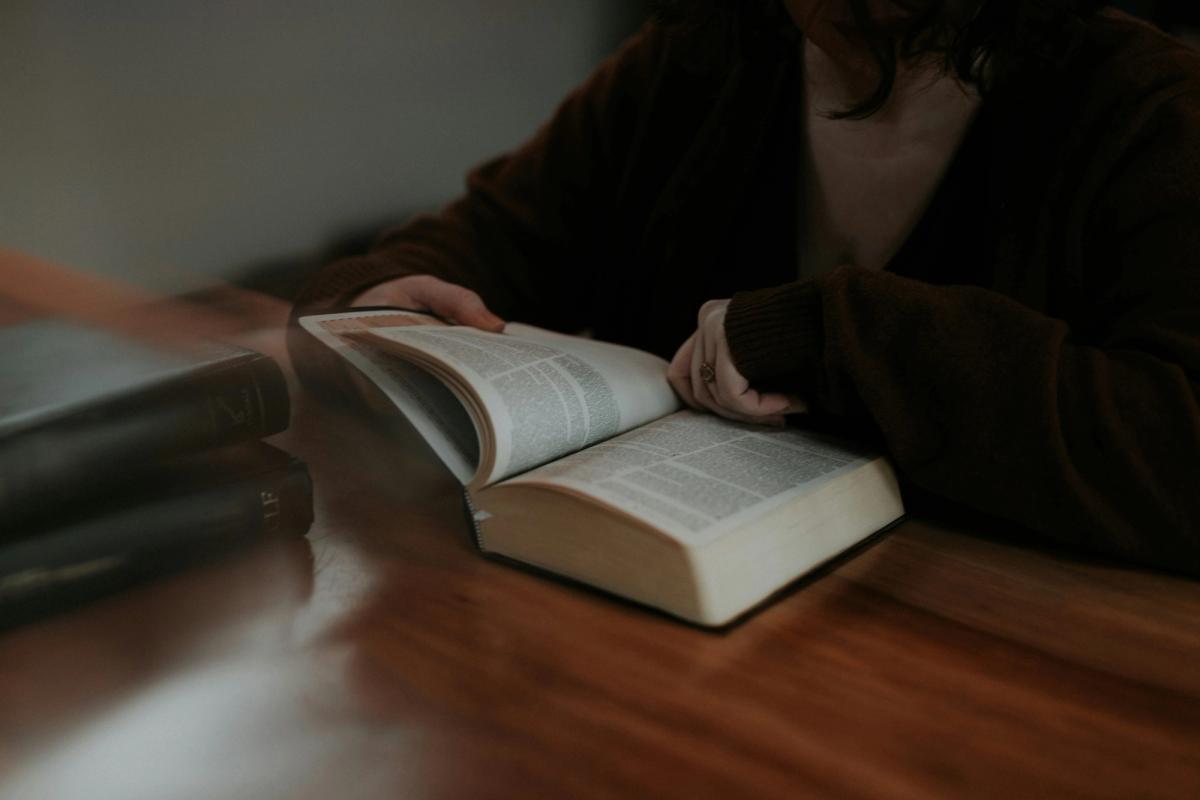 Somebody sat at a desk reading a Bible
