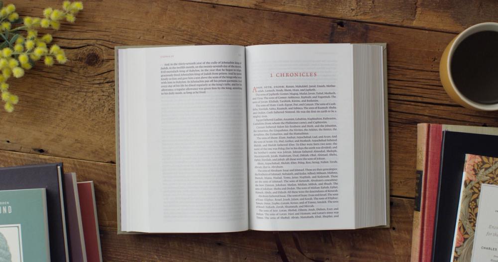 A close-up, top-down shot of an open ESV Reader's Bible. The focus should be on the clean, single-column text without verse numbers. A pair of stylish reading glasses could be resting on the page. This visually demonstrates the unique "novel-like" feature.