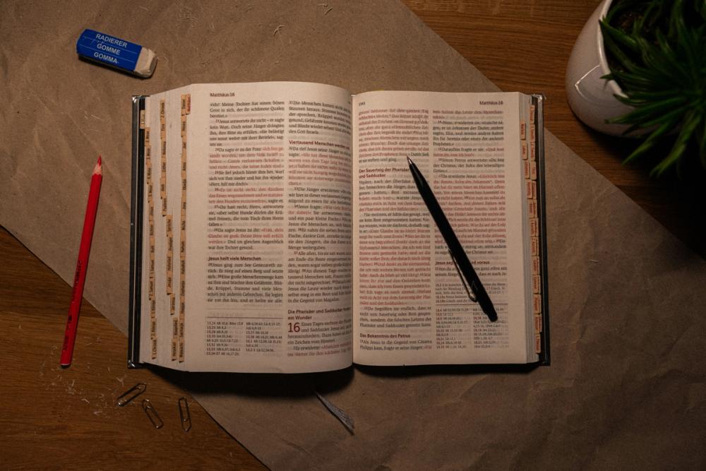An open Bible on a messy desk