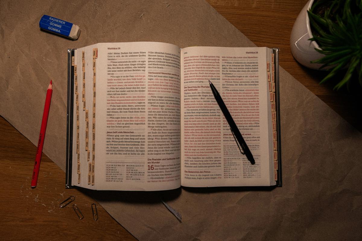 An open Bible on a messy desk
