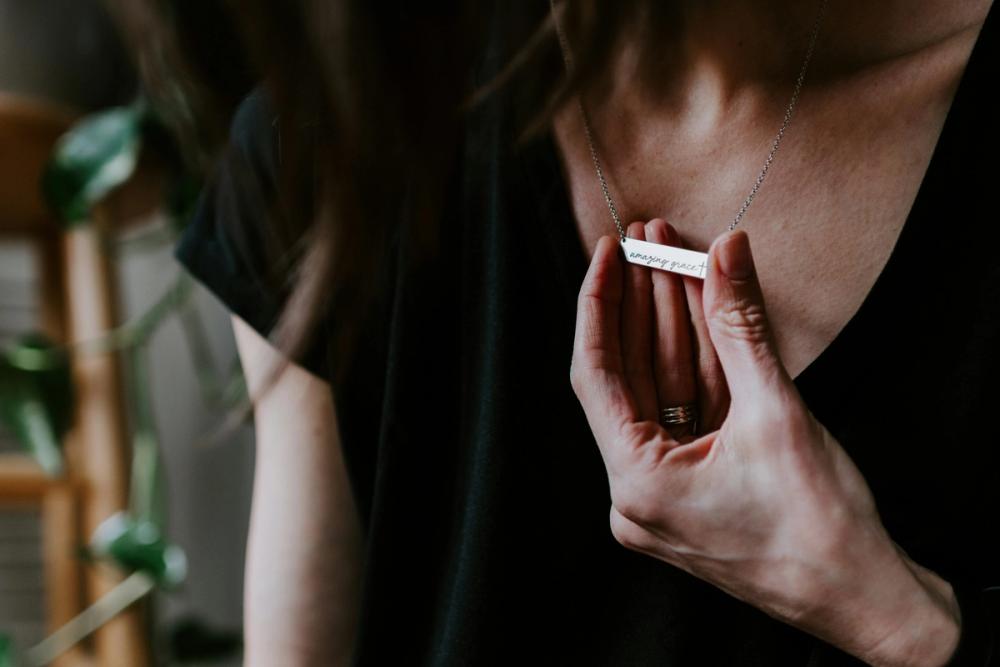 a woman wearing a beautiful christian necklace that was gifted to her