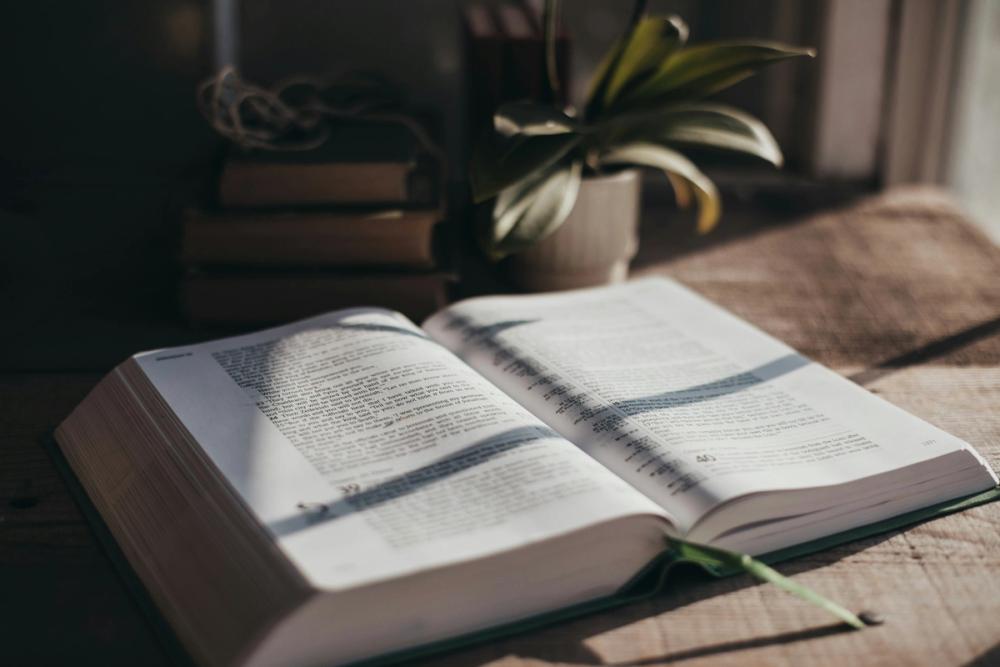 An open, single column bible on a desk in the sunlight
